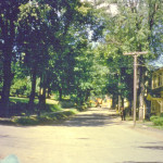 At the intersection of Thousand Acre Rd looking north up Main Street. White VanBuren Funeral Home on right before trees are removed. 19