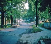 Looking South on Main Street, the White Van Buren Funeral Home on the left (yellow) and the RR tracks in the background with Thousand Acre Rd on right by the RR Crossing sign M-13