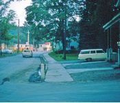 Looking South on Main Street, Carroll’s Store and the old Post Office across from the fire house. M-18
